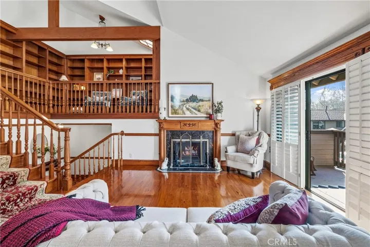 Living room has hickory floor and elegant fireplace. Mezzanine overlooks living room.