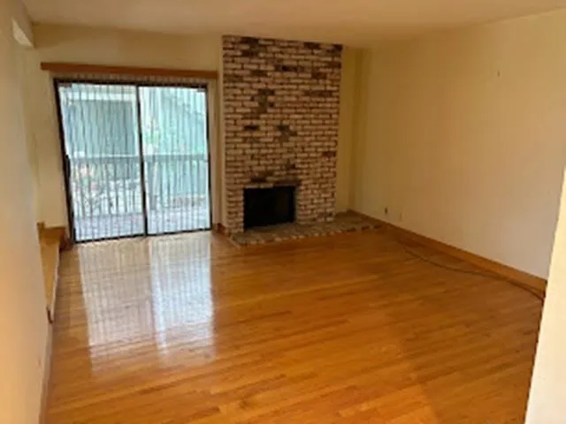 Unfurnished living room featuring light wood-style floors and a fireplace