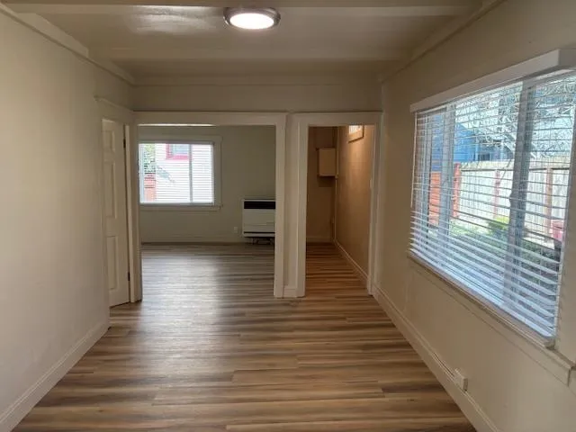 Hallway featuring light wood-style flooring and heating unit