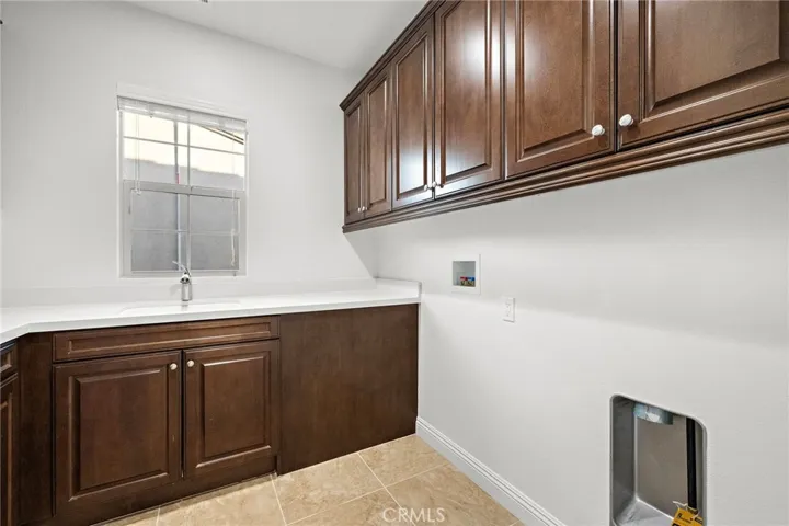 Dedicated laundry room featuring built-in cabinets
