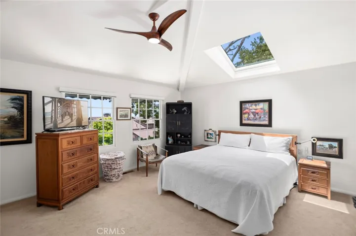 The primary suite is a tranquil sanctuary, featuring sweeping ocean views, natural light throughout, vaulted ceilings, and an oversized skylight that fills the space with sunshine by day and starlight by night.