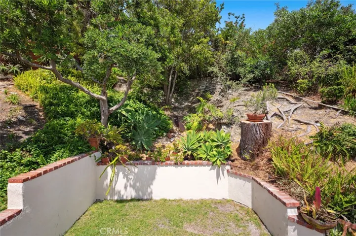 A flat grassy yard and mature landscaping create a peaceful, private outdoor retreat.