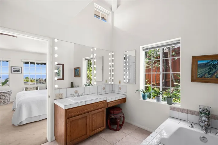 The en-suite bath offers garden views, a soaking tub, and a separate shower for a spa-like experience.