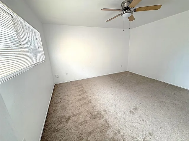 Bedroom Two with new carpet and ceiling fan.
