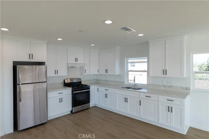 Kitchen with refrigerator included and beautiful quartz countertop.