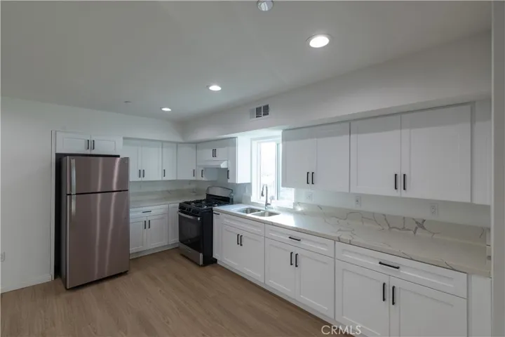 View of Kitchen with refrigerator and beautiful quartz countertops.