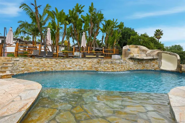 Resort style pool & 8-person spa with lighting, PebbleTec, saltwater system, Wi-Fi controls, decorative slide & waterfall