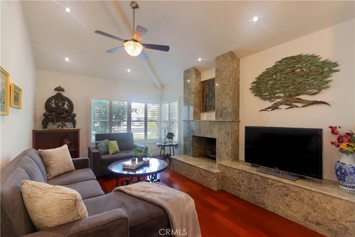 Floor-to-ceiling custom granite fireplace with raised hearth creates beautiful focal point.