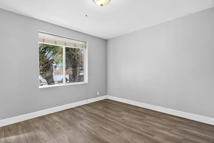 Spare room featuring baseboards and wood finished floors