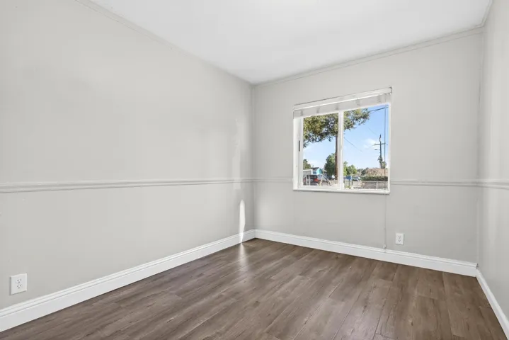 Spare room with wood finished floors and ornamental molding