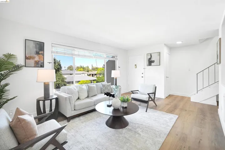 Living area with light wood finished floors and recessed lighting