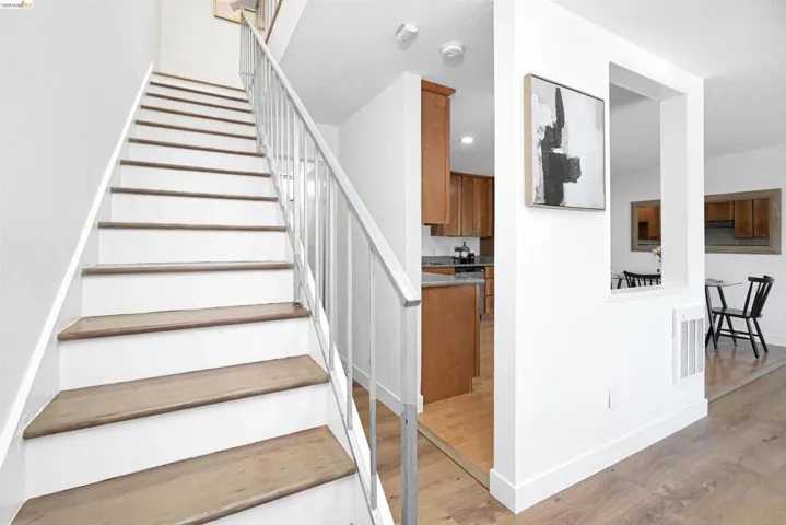 Stairway with wood finished floors and baseboards