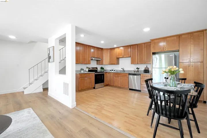 Kitchen with light wood finished floors, stainless steel appliances, recessed lighting, and wood finish cabinetry
