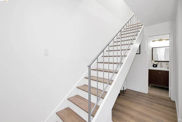 Stairway with wood finished floors and baseboards
