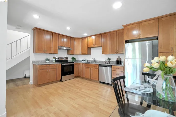 Kitchen featuring stainless steel appliances, light wood-style flooring, recessed lighting, wood finish cabinets, and light stone countertops