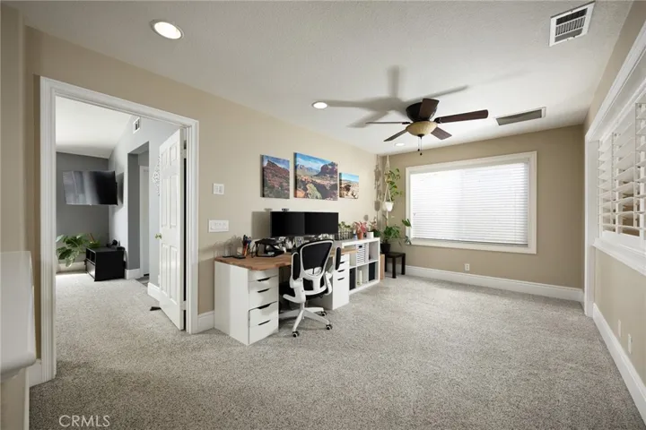 Upstairs is a large loft with plantation shutters that offers flexible space for a media room, home office, playroom, or additional lounge area.