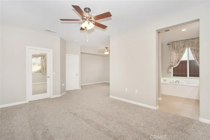 Main bedroom with view to walk in closet, sitting area, and ensuite bathroom