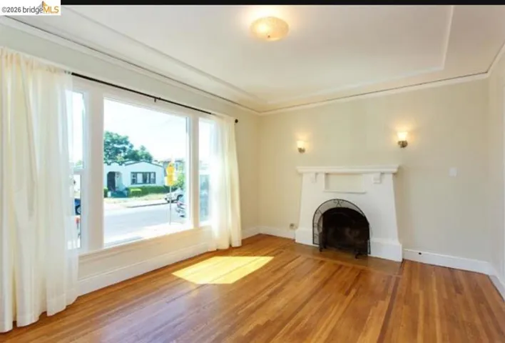 Unfurnished living room with a fireplace, light wood-style floors, and ornamental molding