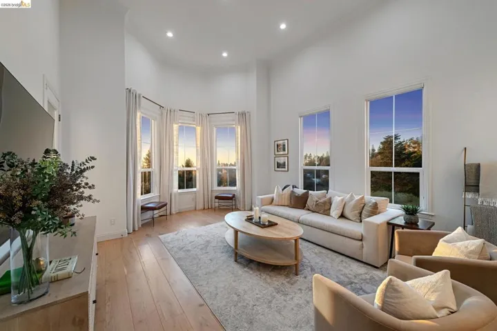 Living area with a high ceiling, light wood-style floors, recessed lighting, and crown molding