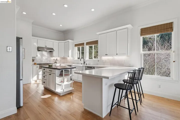 Kitchen with white cabinetry, crown molding, open shelves, a peninsula, and tasteful backsplash