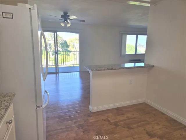 Dining area under ceiling fan toward balcony view from kitchen