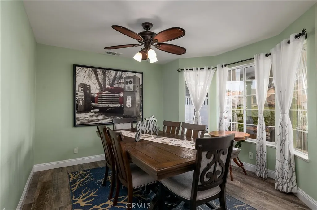 Spacious dining area with large windows overlooking the front garden, perfect for hosting dinners and gatherings in a warm, inviting setting.
