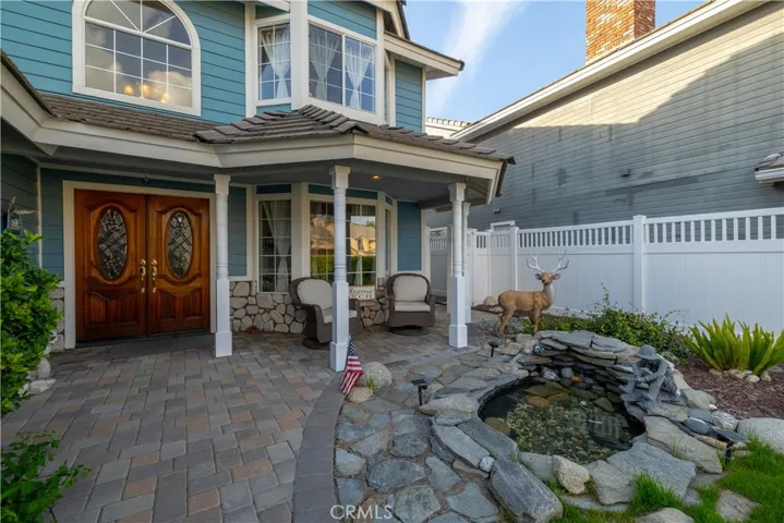 The gorgeous stonework compliments the cape cod entry, with a relaxing front porch and water feature to enjoy.