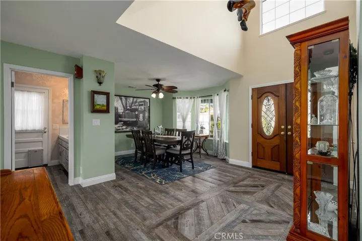 Light-filled entryway with dramatic vaulted ceilings, beautiful wood doors, and stylish flooring flowing seamlessly into the dining area.