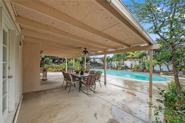 Covered patio area with dining set overlooking the pool—ideal for outdoor meals and lounging.
