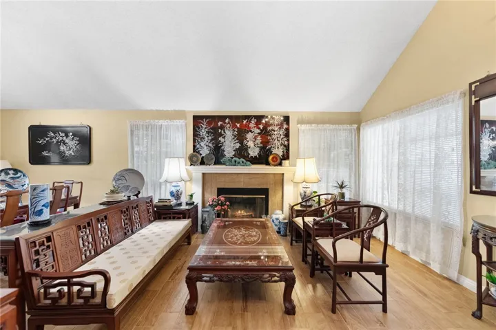 Another view of the inviting living space featuring the fireplace, multiple windows, and an easy flow to the dining area.
