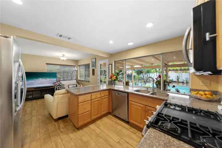 Open kitchen overlooks an adjacent living area with direct access to the patio and backyard, enhancing everyday functionality.
