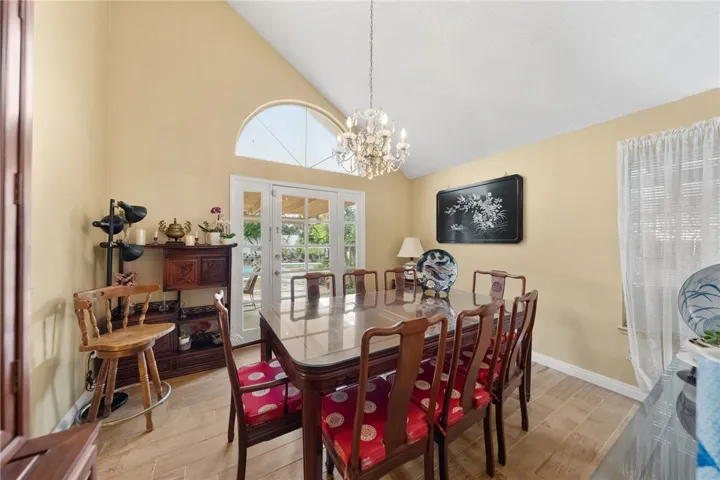 Light-filled dining area with chandelier and French doors leading to the covered patio for indoor-outdoor entertaining.
