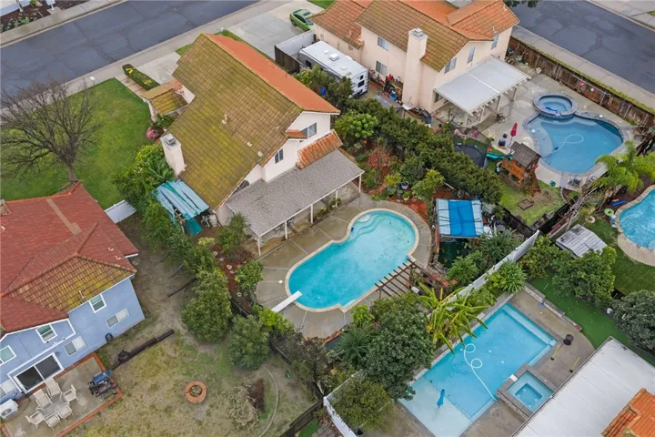 Overhead perspective highlighting the home’s backyard layout with pool and surrounding landscaping