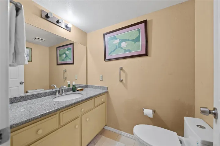 Clean bath with a wide vanity, granite-style countertop, and ample mirror space.