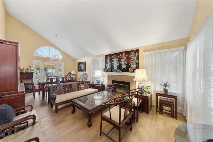 Spacious gathering area with vaulted ceiling, abundant natural light, and fireplace—ideal for relaxing or entertaining.
