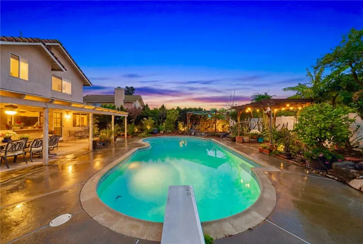 Resort-style backyard with a freeform pool, expansive deck space, and a covered patio—ideal for outdoor dining and entertaining.
