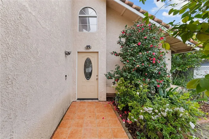 Welcoming covered entry with a tiled porch and the beautiful camelia tree!