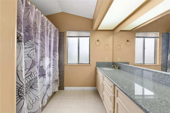 Another angle showcasing the dual vanity, natural light from the window, and expansive counter space.
