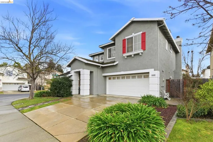 Traditional-style home featuring a garage, stucco siding, concrete driveway, and a chimney