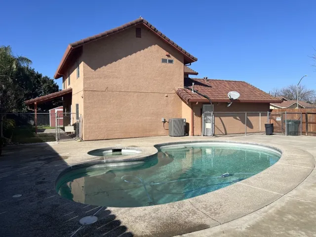 Integrated pool / spa featuring a gate and a patio