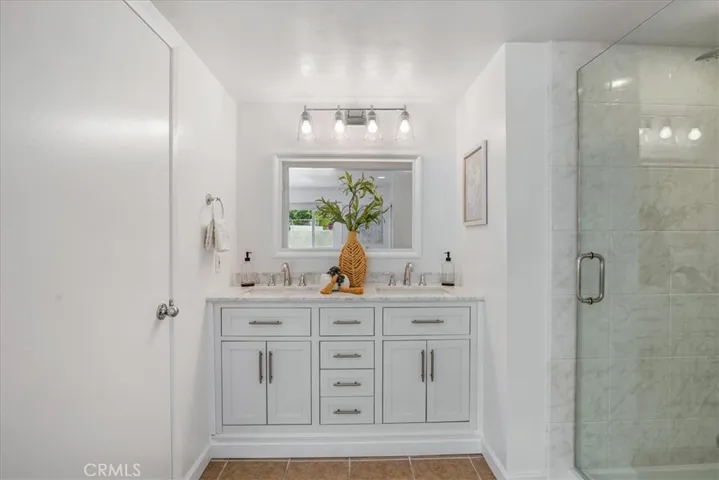 Primary bathroom with shower on one side, then another bathroom with shower and tub on the left