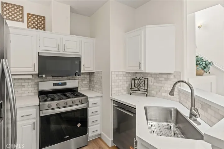 Kitchen with new stove featuring 5 gas burners, new microwave & dishwasher snd new kitchen sink snd quartx countertops and backsplash