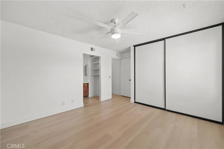 Primary Bedroom with ensuite vanity and privacy door to shower