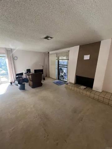 Open living room with a fireplace and extra end-unit windows not found in interior units.