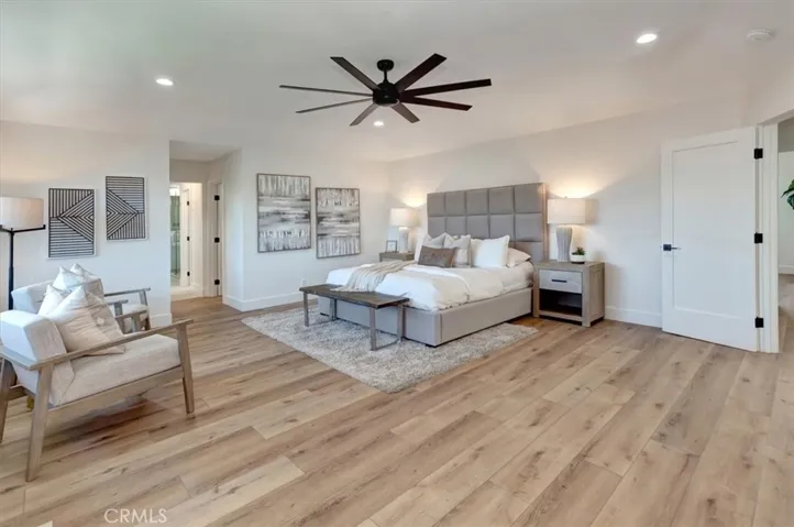 Upstairs, a custom iron staircase leads to four spacious bedrooms, including a luxurious primary suite with coffered ceilings, a dramatic floor-to-ceiling tiled fireplace