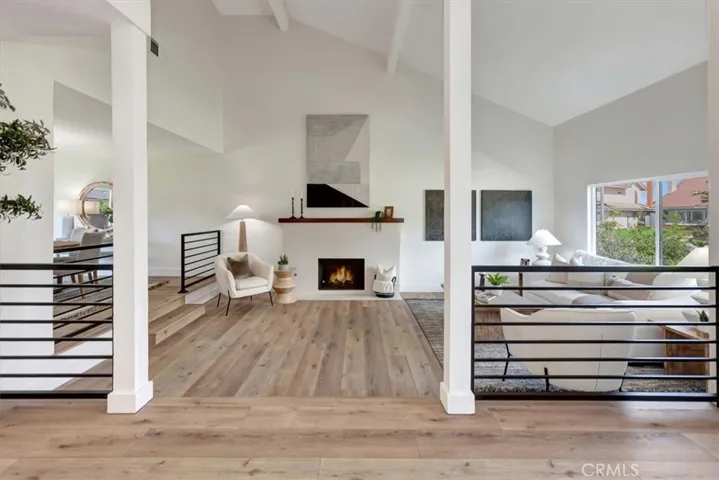 Step-down formal living room with soaring vaulted ceilings and a statement fireplace.