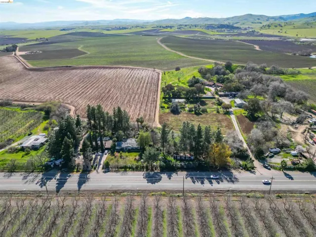 Aerial view of sparsely populated area with large plots for crops and mountains