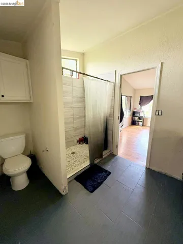 Bathroom with a shower stall and a textured wall