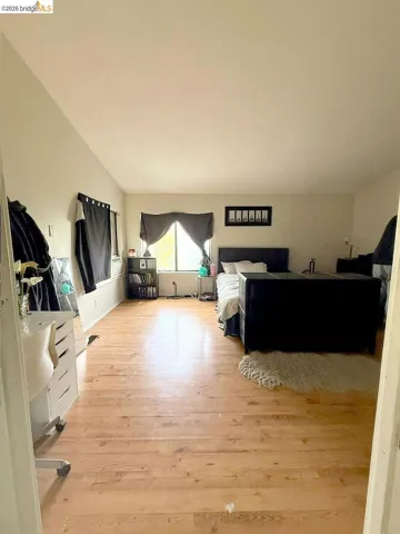 Bedroom featuring light wood finished floors and vaulted ceiling