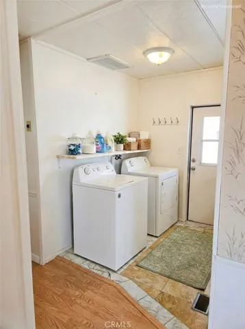 Laundry area at carport door side. Image has been digitally staged, washing machine not included.